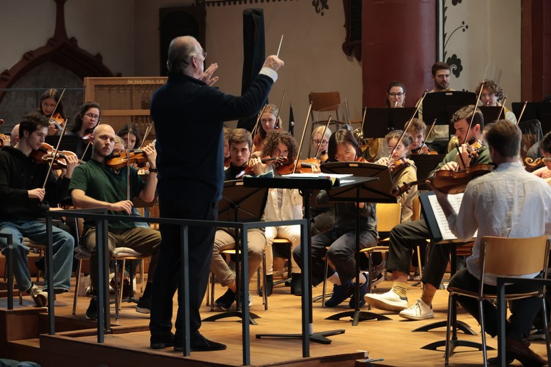 Ein Dirigent steht vor dem Orchester