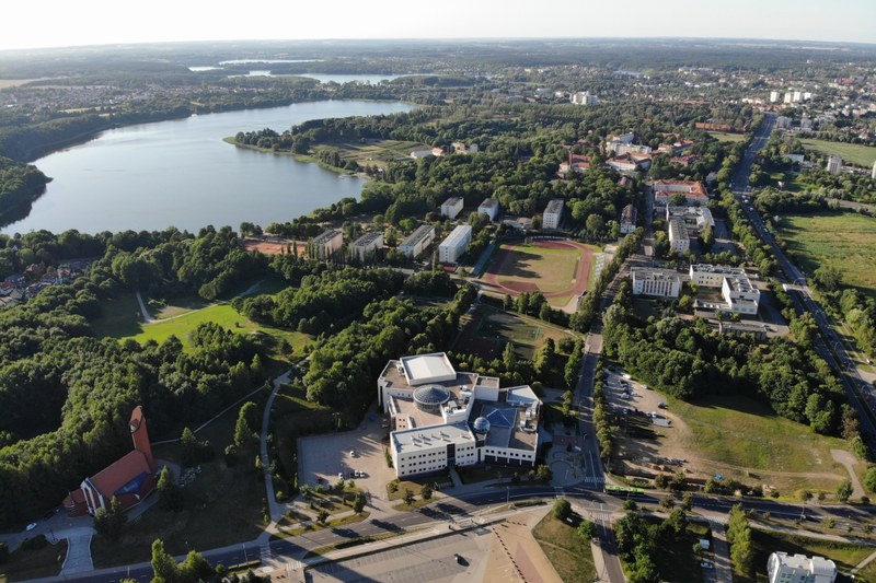 Luftbild vom Campus der Universität Olsztyn mit weitläufigem Gelände und grossem See
