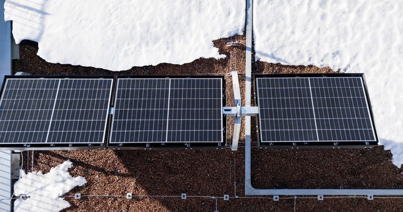 Solarpaneel auf einem Dach umgeben von Schnee