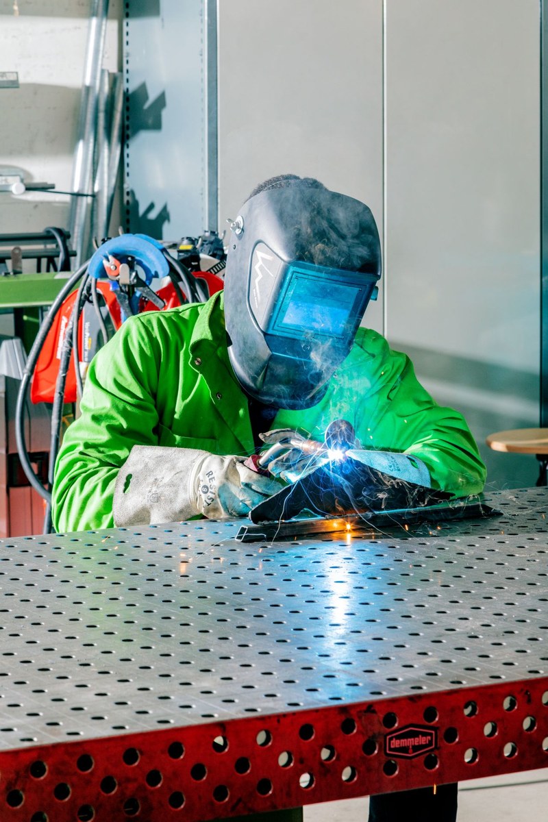 Eine Person mit Schweissmaske am Schweissen