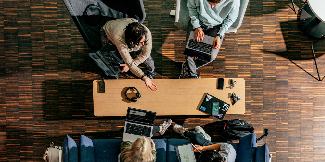 Studierende arbeiten an einem Tisch zusammen, um Probleme zu stemmen