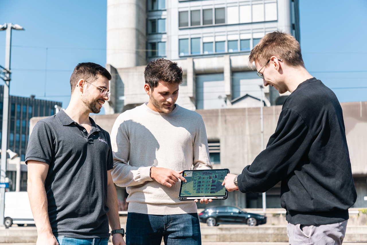 Three young adults working on a tablet